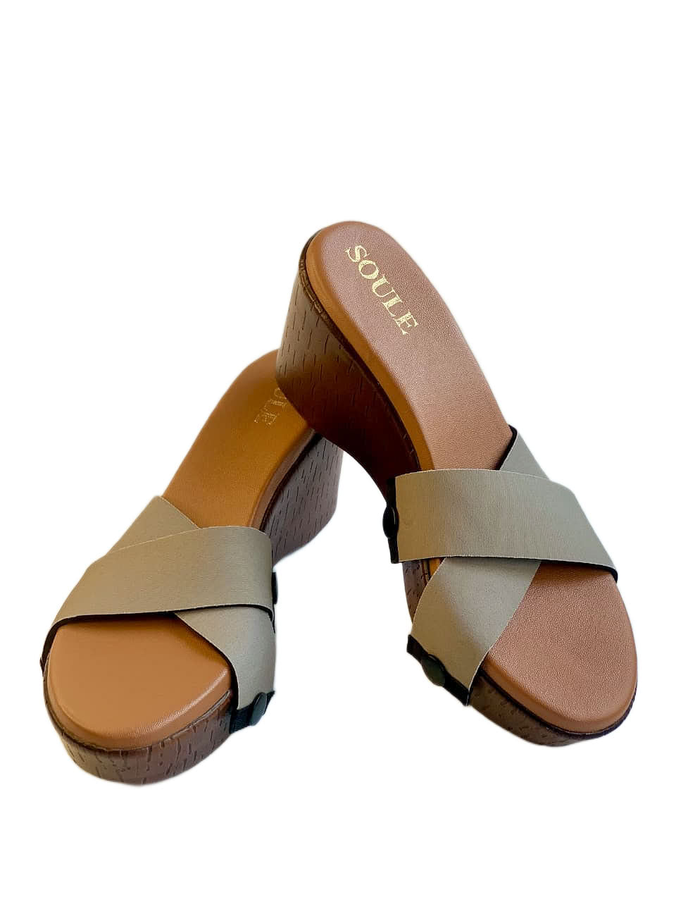 Close-up of cork wedge slide sandals with black snap clips and warm beige criss-cross straps on white background by Soule Footwear