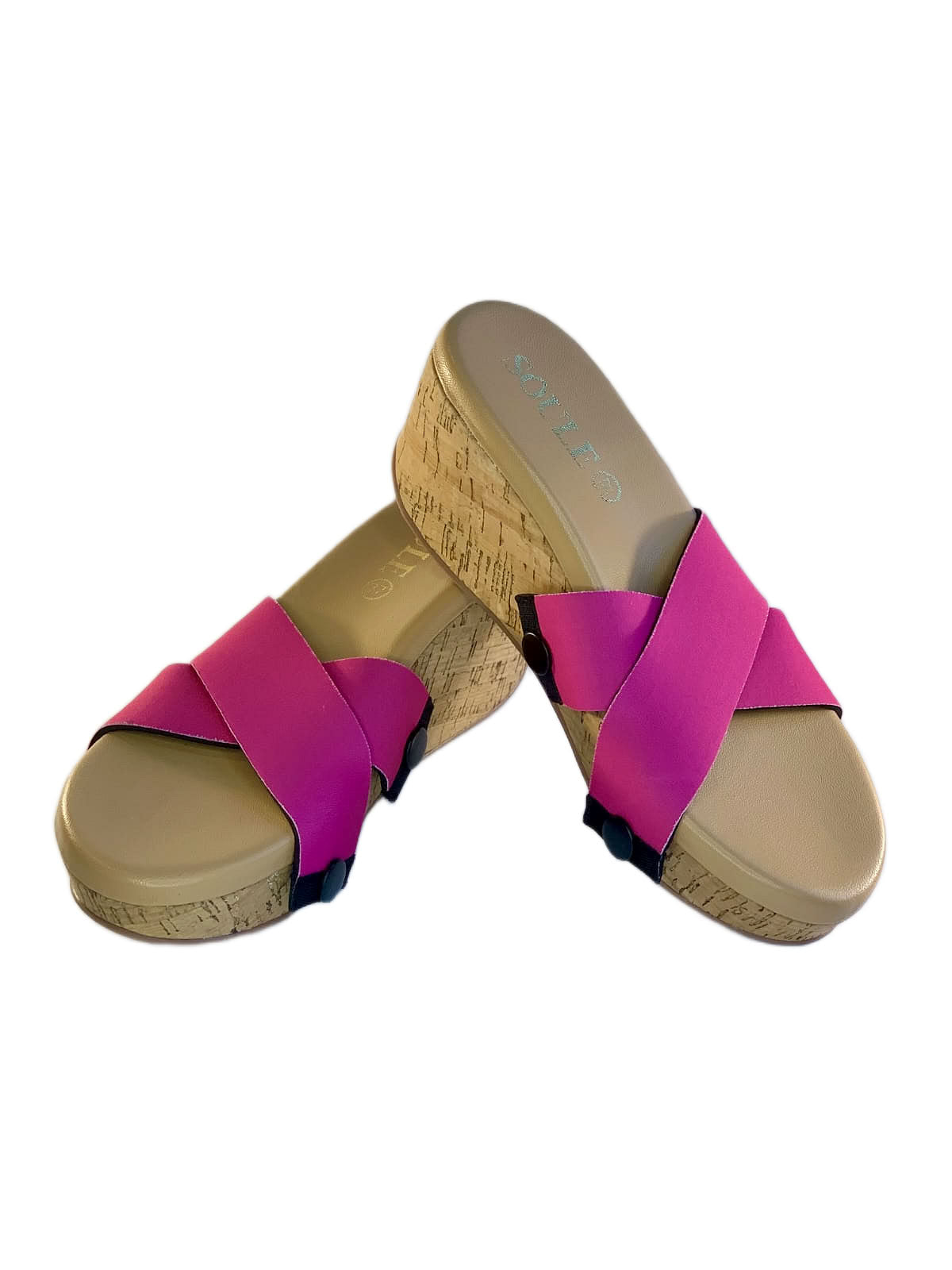 Close-up of cork wedge slide sandals with black snap clips and bold shocking pink criss-cross straps on white background by Soule Footwear