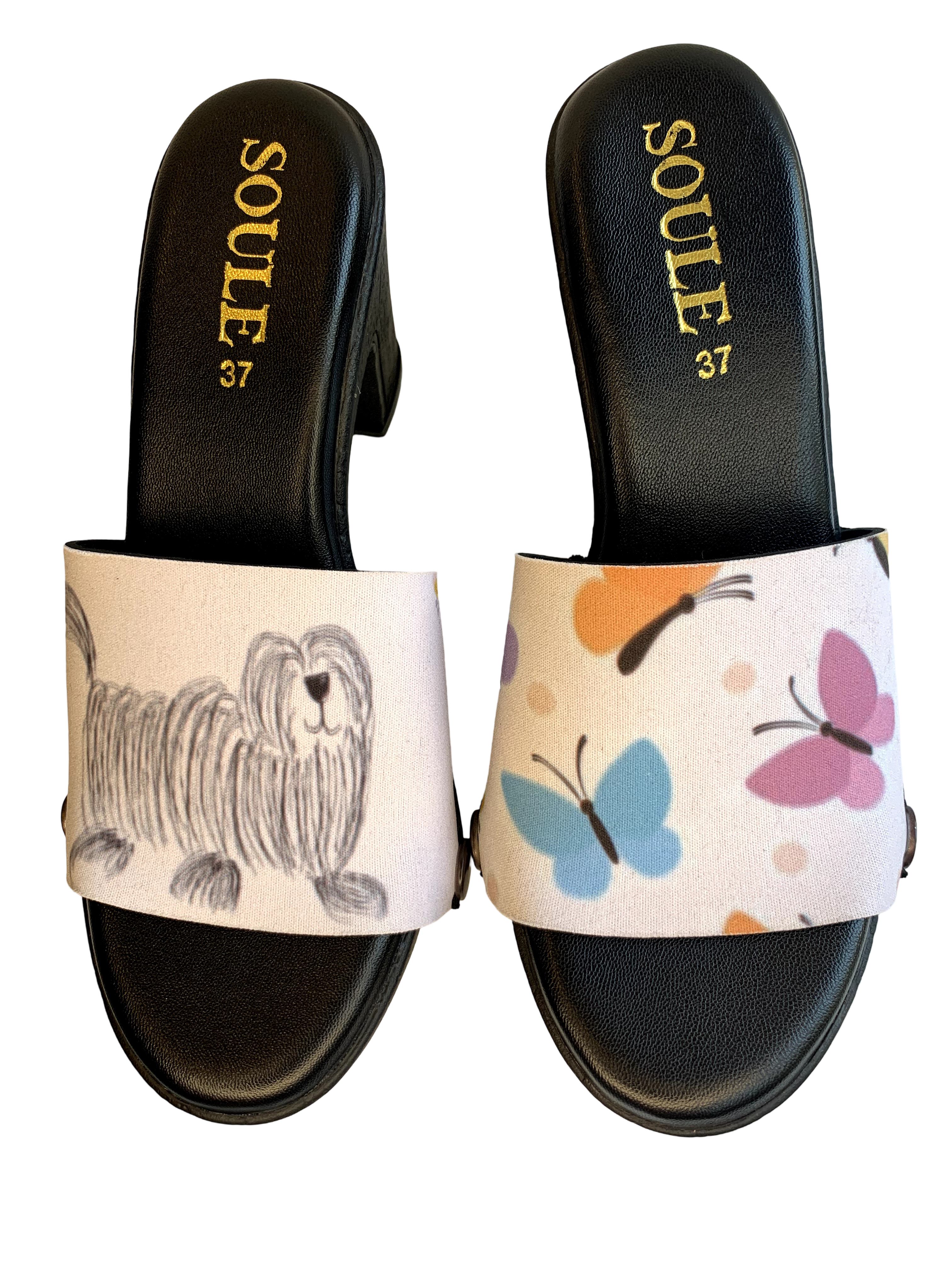 Fluffy & Flutter snap-on shoe strap set close-up on black heel - pencil-sketch fluffy dog with butterfly on cream and pastel butterflies on cream by Soule