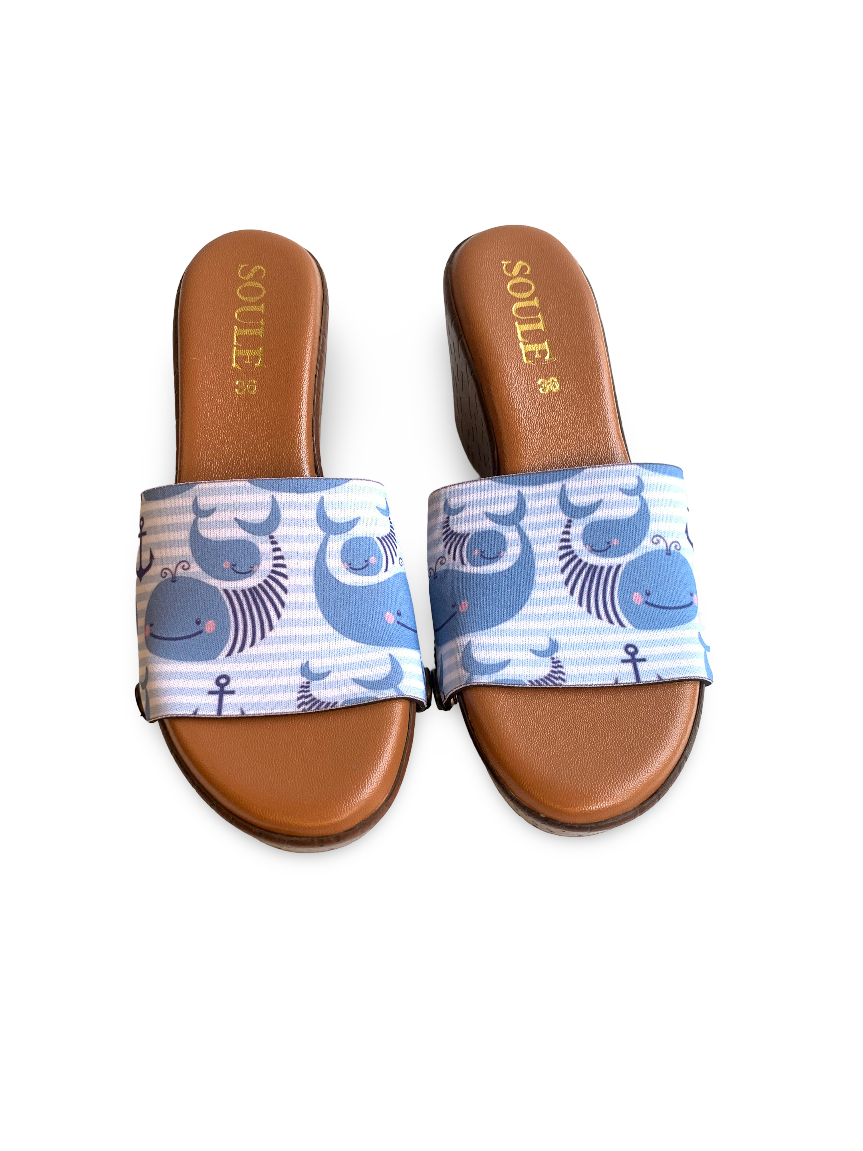 Close-up of Whale of a Time interchangeable strap on brown wedge sole by Soule Footwear on white background