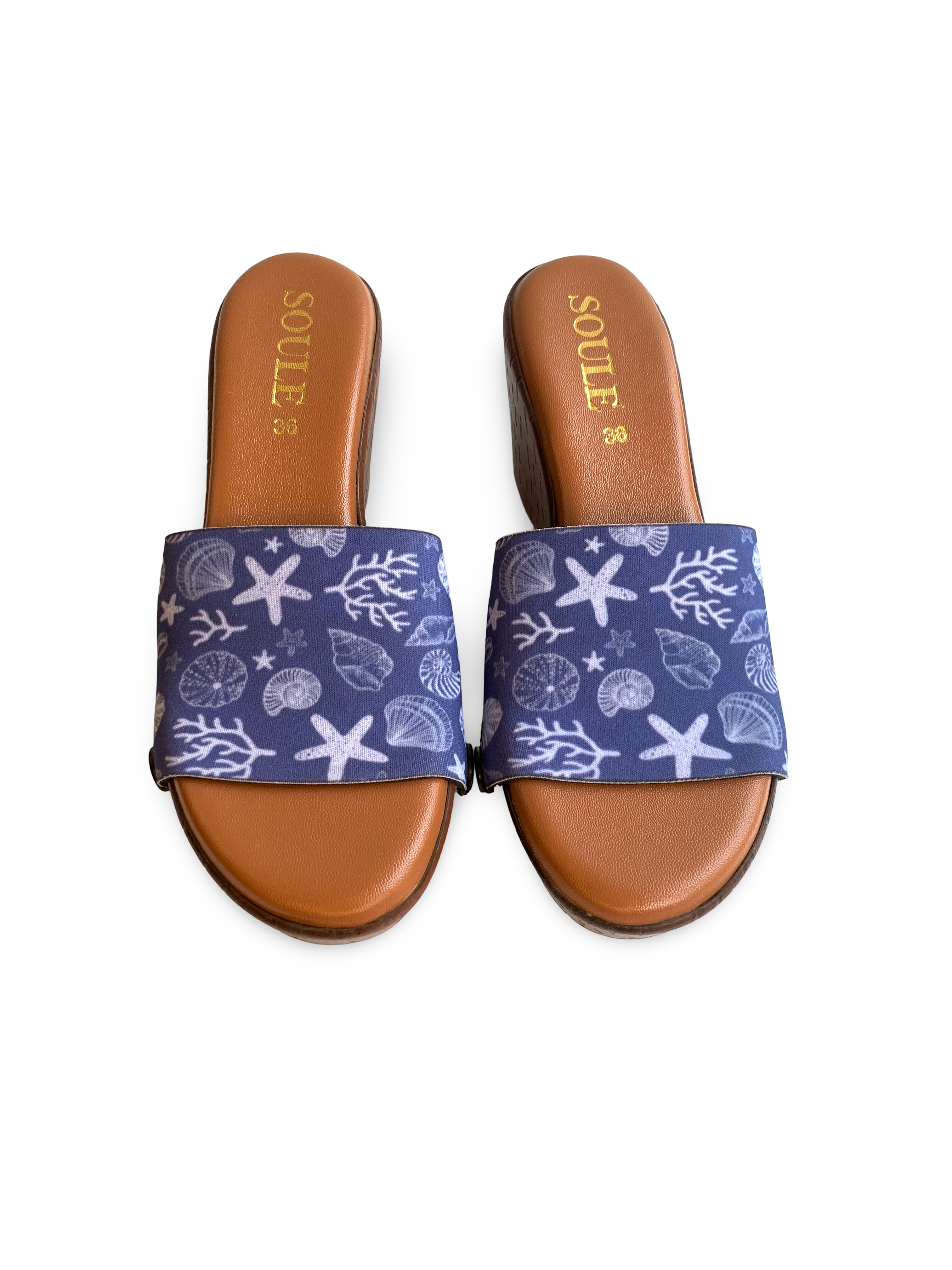 Close-up of Seashell interchangeable strap on brown wedge sole by Soule Footwear on white background