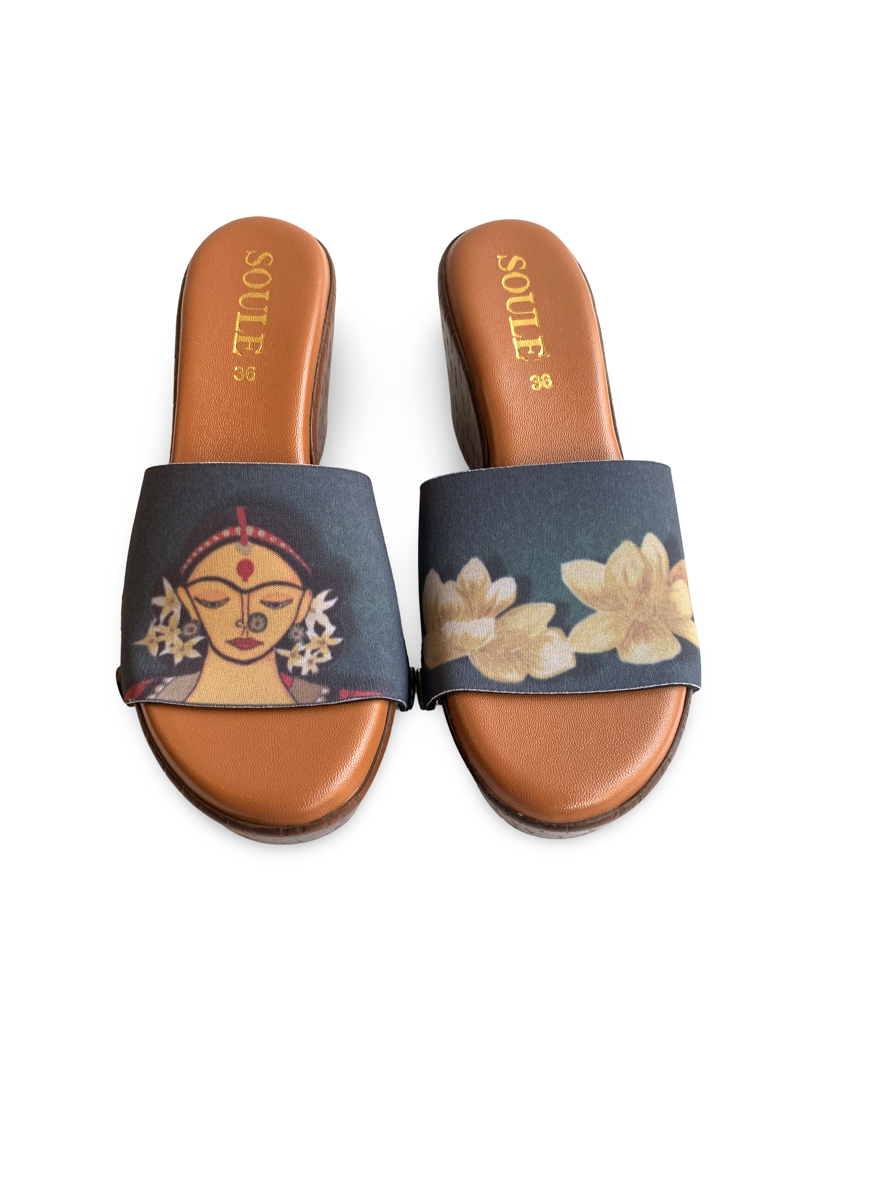 Close-up of Divine Goddess strap sandal — golden lotus flowers and Goddess Durga face illustration on brown wedge sole with black snap closures, by Soule Footwear