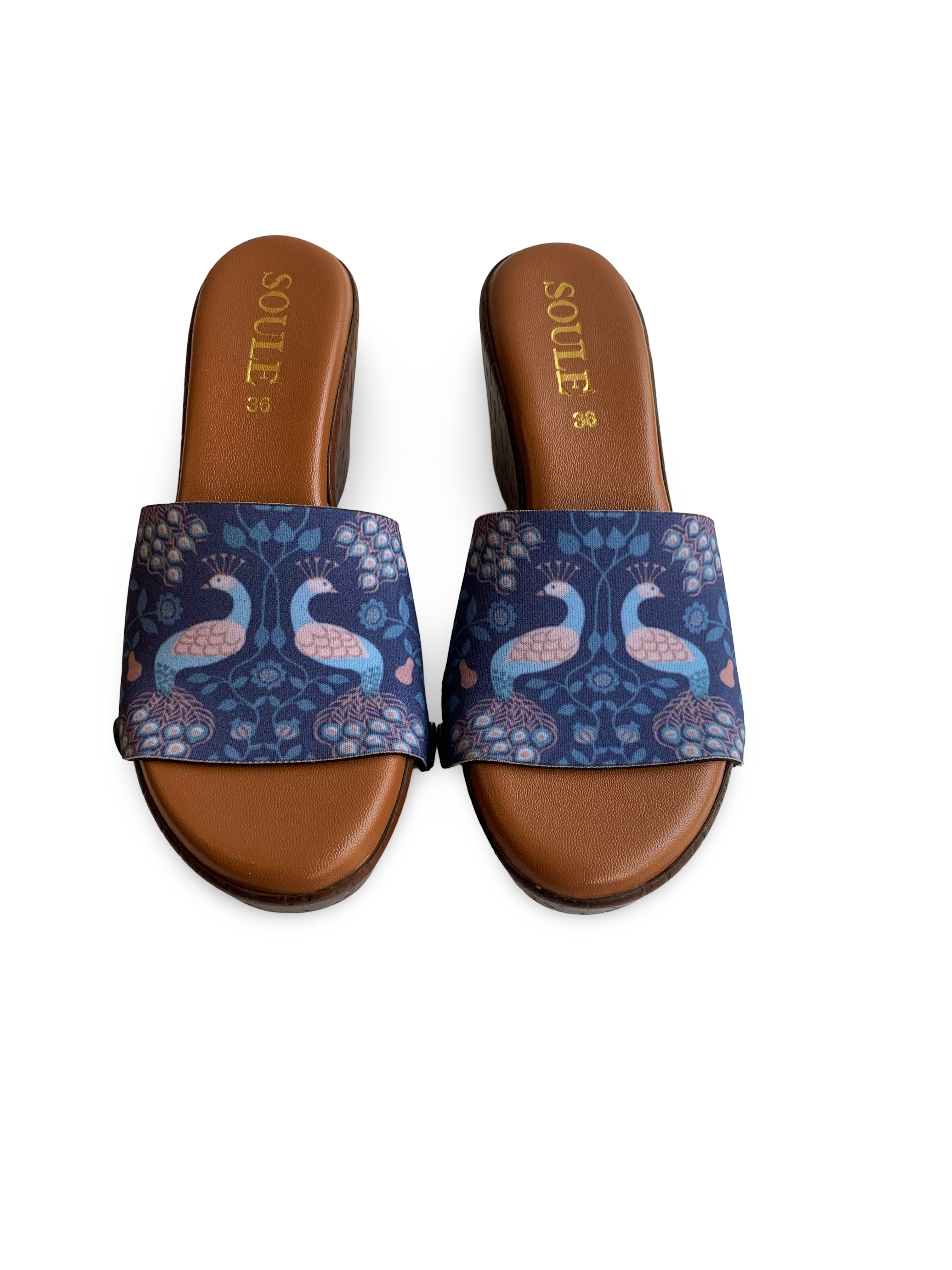 Close-up of Royal Peacock strap sandal — deep navy peacock tapestry print with teal and blush pink floral vines on brown wedge sole with black snap closures, by Soule Footwear