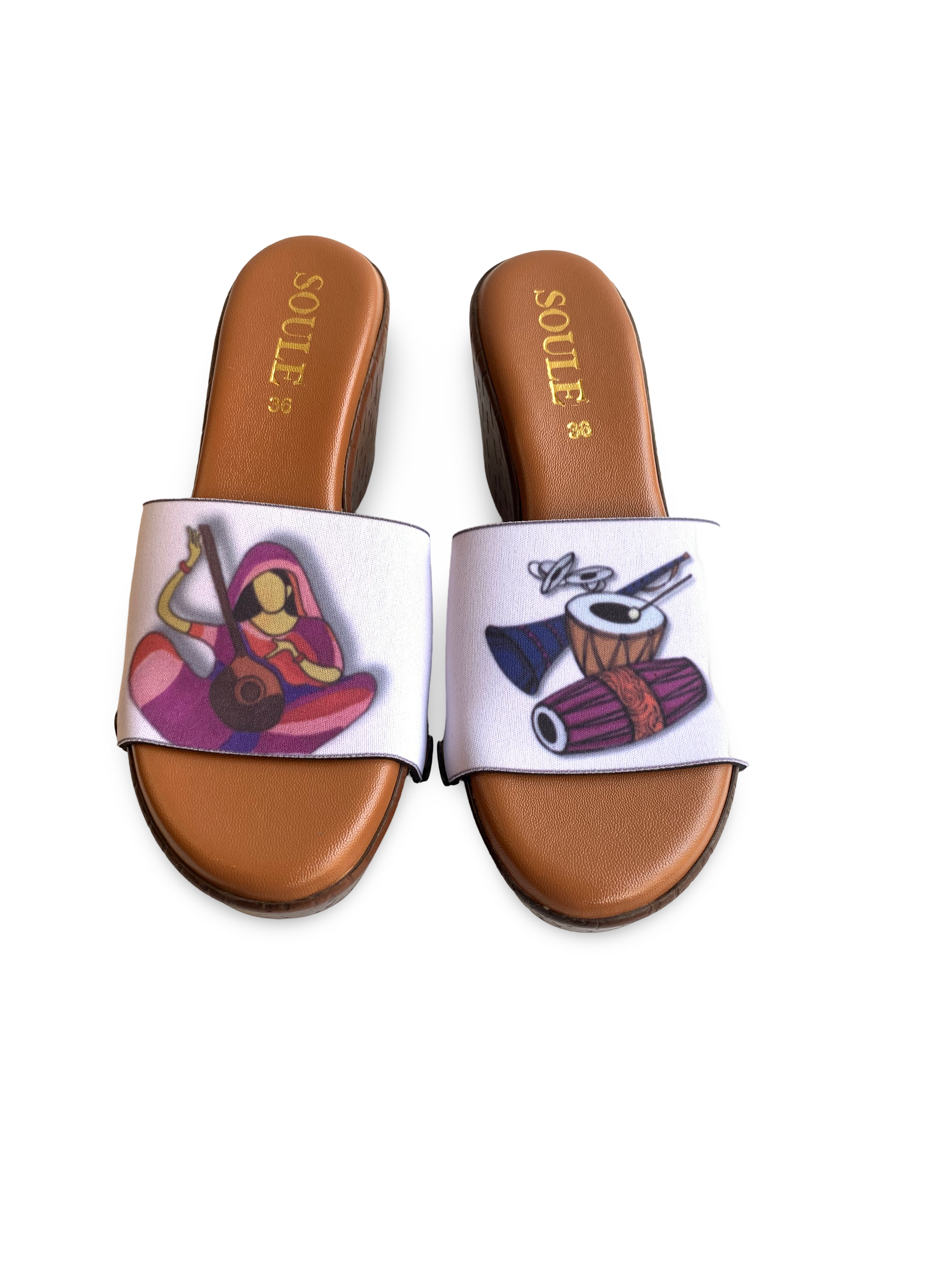 Close-up of Raaga strap sandal — Indian classical music illustration with veena musician and tabla drums on  brown wedge sole with black snap closures, by Soule Footwear
