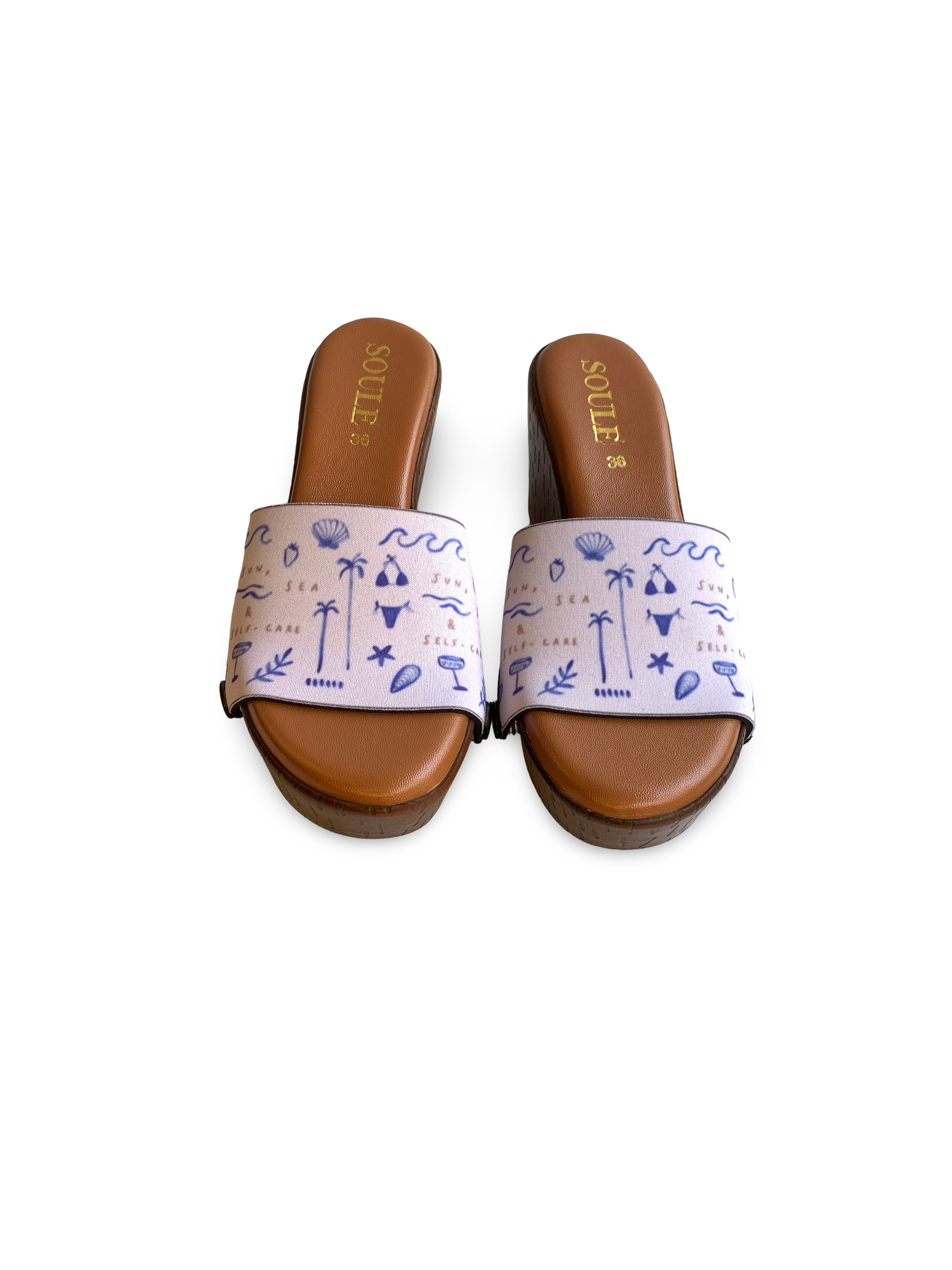 Close-up of Sun & Sea interchangeable strap on cork wedge sole by Soule Footwear on white background