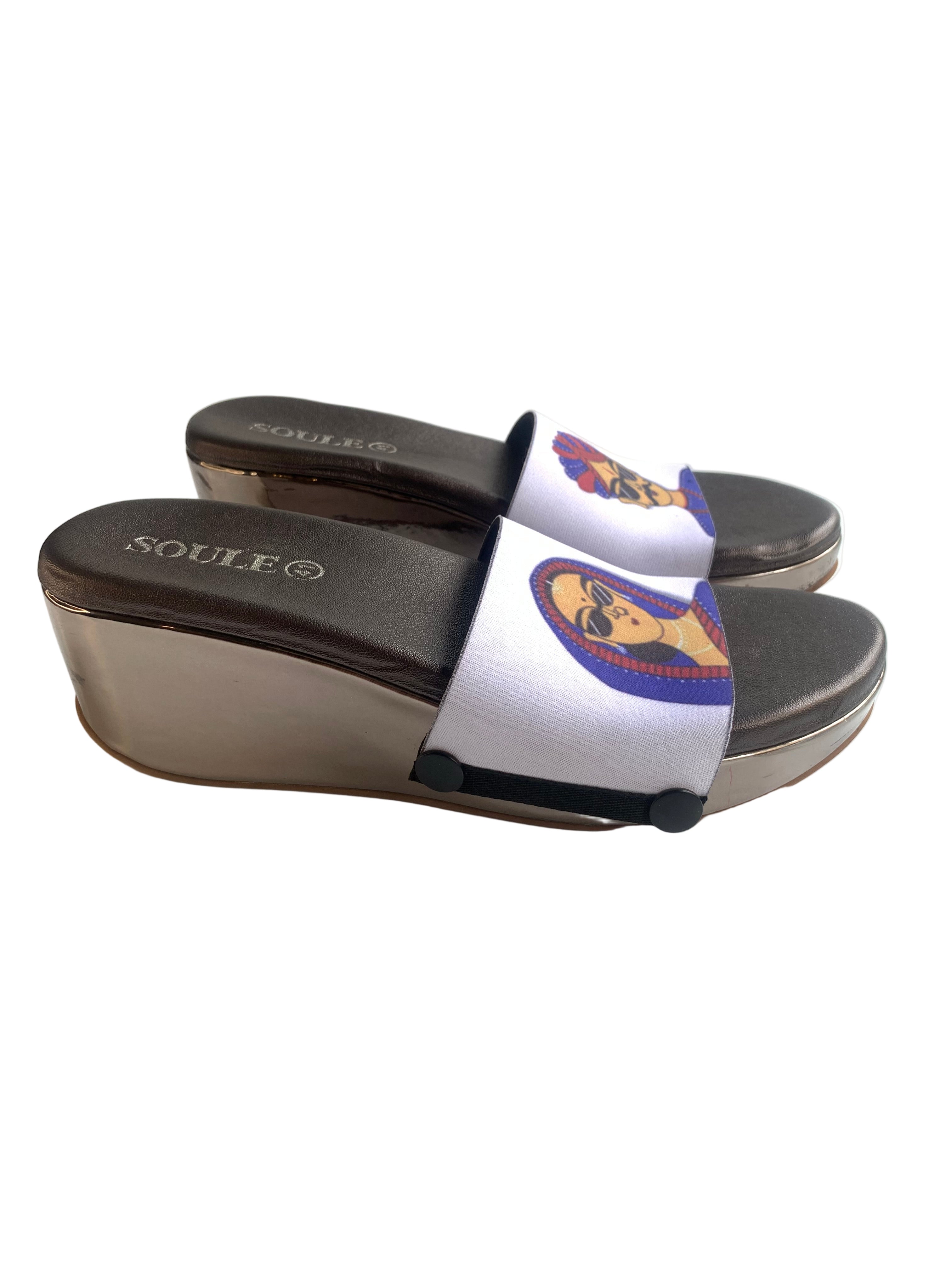 Close-up of Desi Cool strap sandal — quirky Rajasthani folk art woman in blue saree and sunglasses on gun metal wedge sole with black snap closures, by Soule Footwear