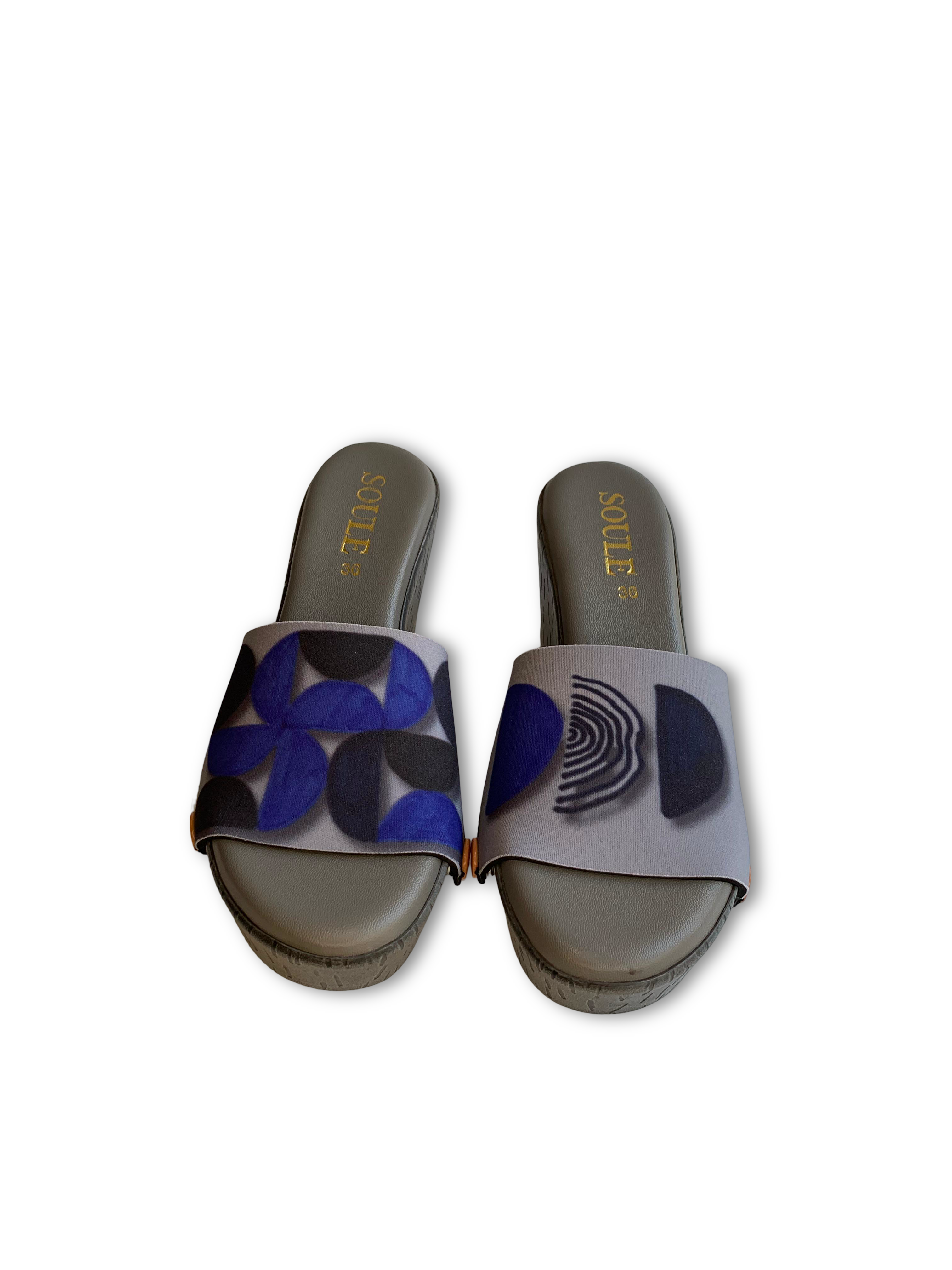 Geometric snap-on shoe strap close-up on cork wedge - silver grey with navy mosaic and concentric arch by Soule